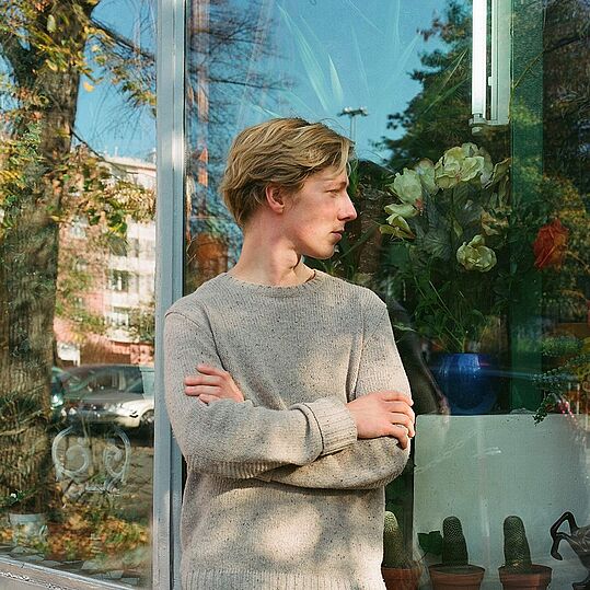 Olivier Heim im Profil vor einem Schaufenster.