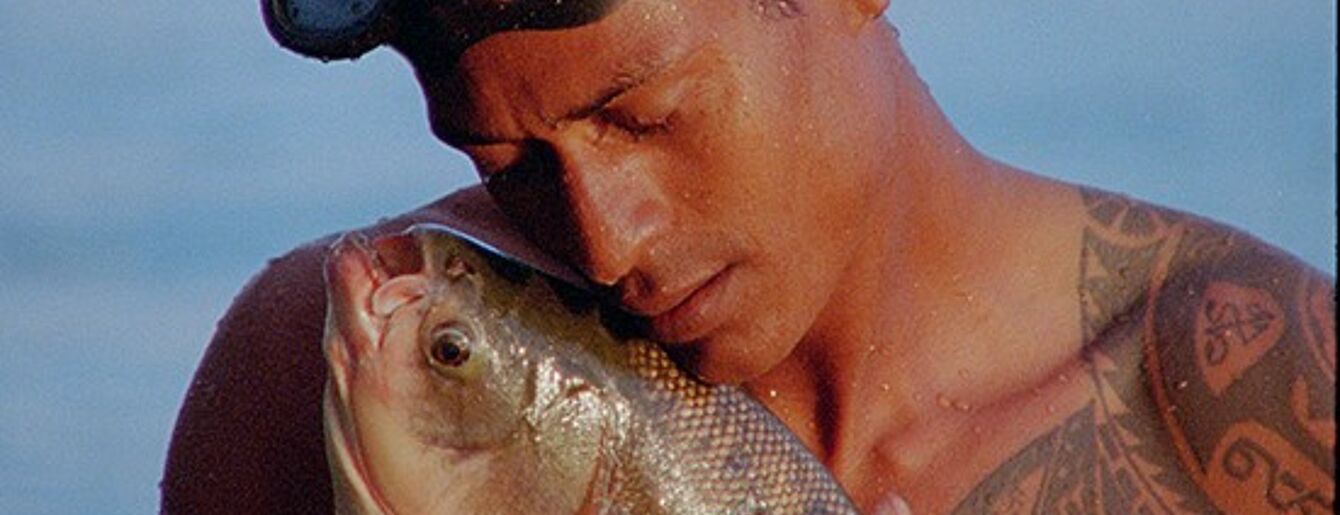 Ein Mann hält zärtlich einen großen Fisch im Arm