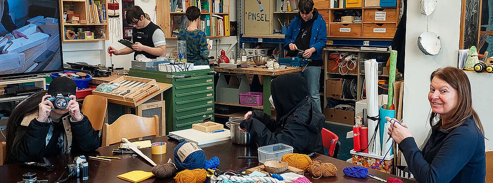 Eine Trainerin mit 5 Teilnehmer_innen bei der Arbeit in der Werkstatt