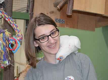 Eine junge Frau mit Papagei auf der Schulter