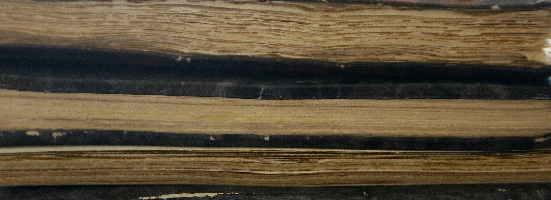 Ausschnitt eines Bücherstapel von unten mit groben Seiten
