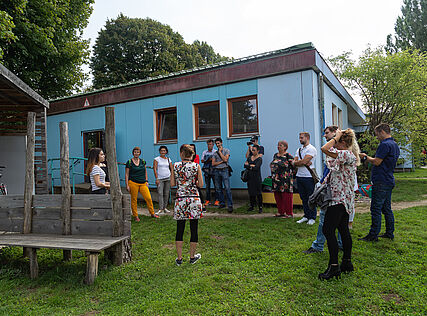 Eine Runde von Menschen im Garten bei der Haus- und Hofführung