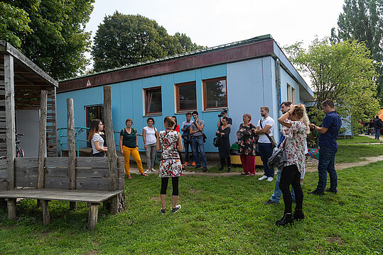 Eine Runde von Menschen im Garten bei der Haus- und Hofführung