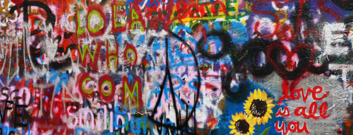 Vollgeschriebene Wand mit Peace-Zeichen
