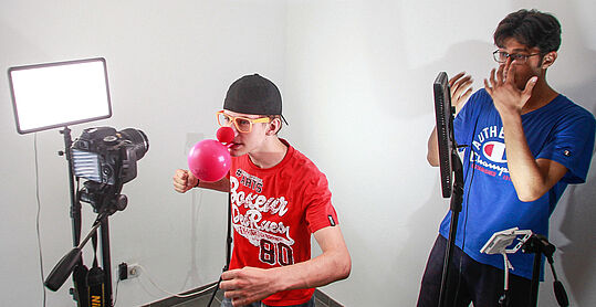Zwei Jugendliche machen ein lustiges Foto mit Clownnase und Luftballon