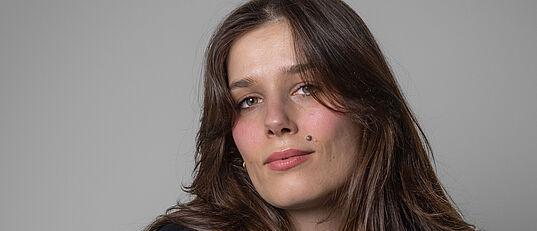 Ein Bild einer weiblich gelesenen Person mit langen dunklen Haaren