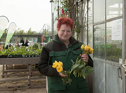 Mitarbeiterin von WUK bio.pflanzen mit Blumen
