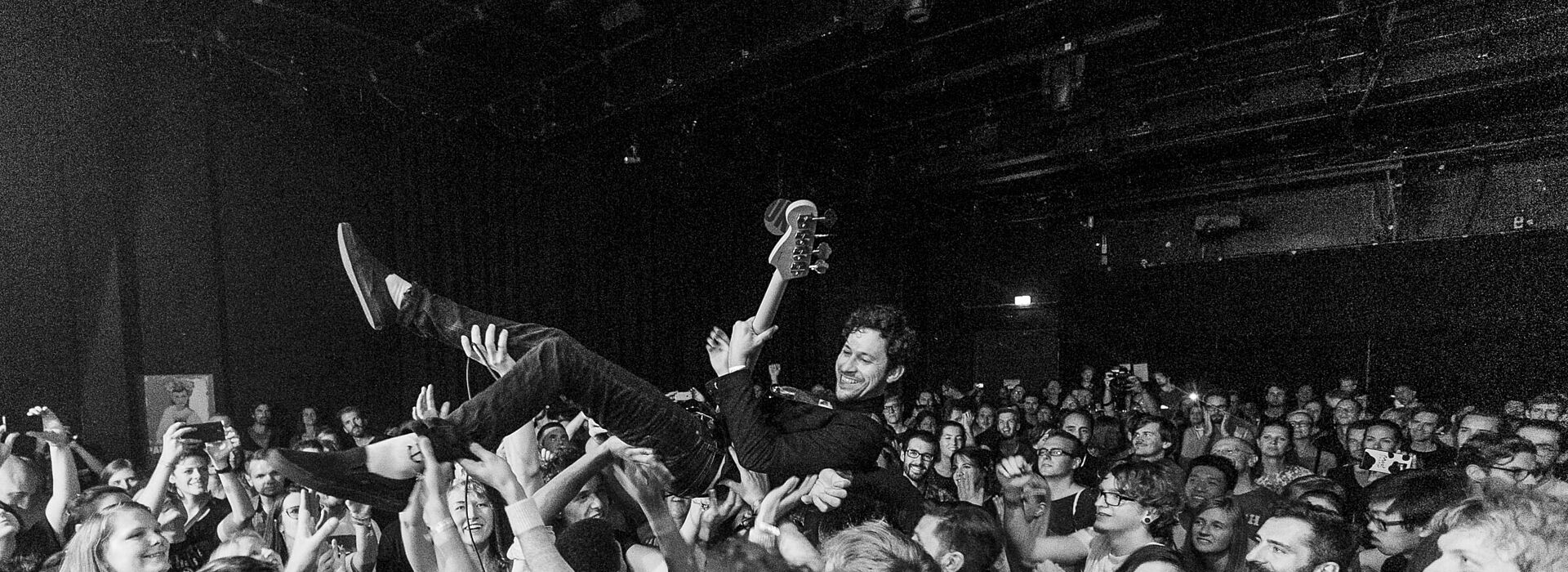 Stagediver mit Gitarre, schwarz-weiß-Fotografie