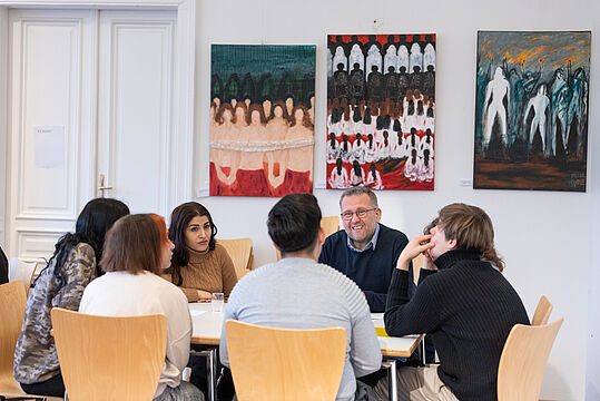 Mehrere Menschen unterhalten sich um einem Tisch