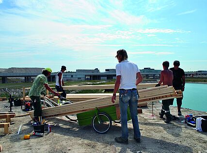 Junge Menschen bauen einen Steg in der Seestadt