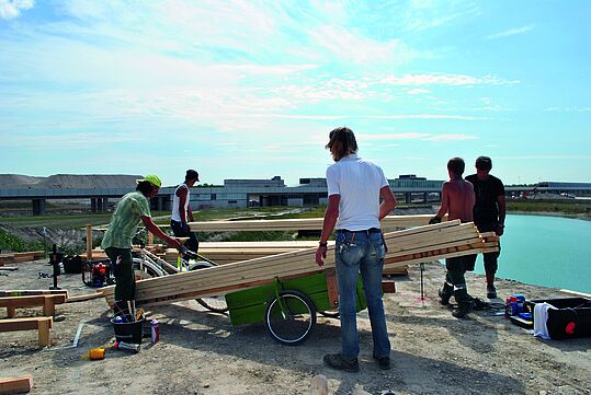 Junge Menschen bauen einen Steg in der Seestadt