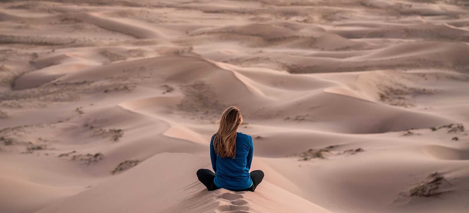 Eine Frau sitzt in der Wüste