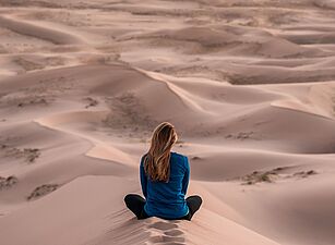 Eine Frau sitzt in der Wüste