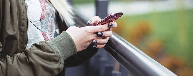 Hände mit Mobiltelefon