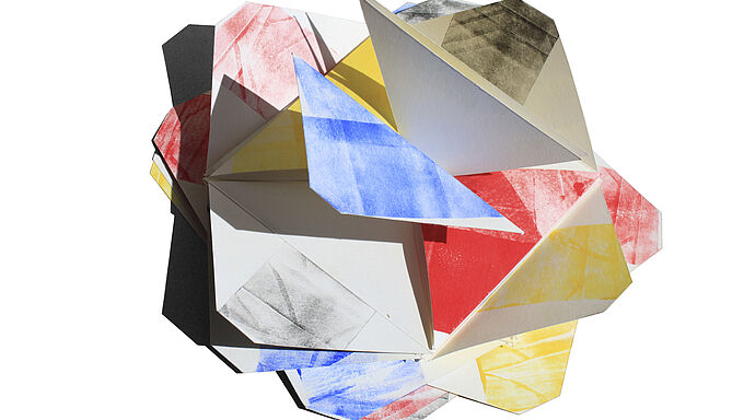 Bunte, dreidimensionale Papierform aus gefalteten Dreiecken mit roten, blauen, gelben und schwarzen Farbflächen