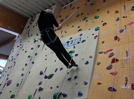 Eine Person beim Klettern in der Kletterhalle 