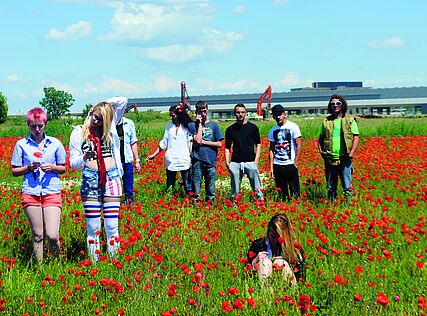 Jugendliche psoeren in einer Blumenwiese