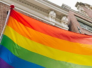 Eine Regenbogenfahne vor einem Gebäude