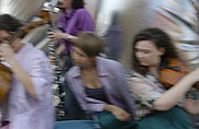 vUnscharfe Aufnahme von mehreren Personen, die Musikinstrumente spielen