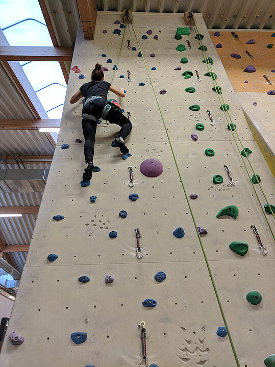 Eine Person beim Klettern in der Kletterhalle 