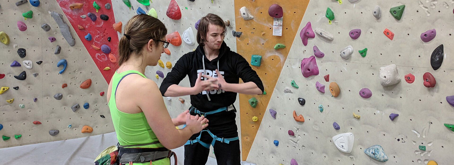 Zwei Personen vor der Kletterwand in der Kletterhalle 