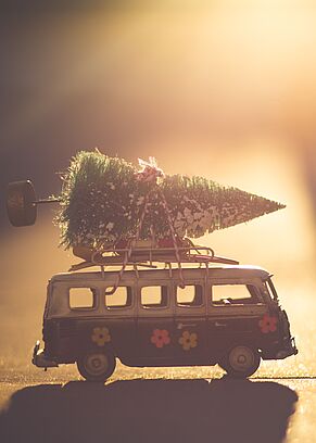 Ein Spielzeug-VW-Bus mit einem Weihnachtsbaum am Dach