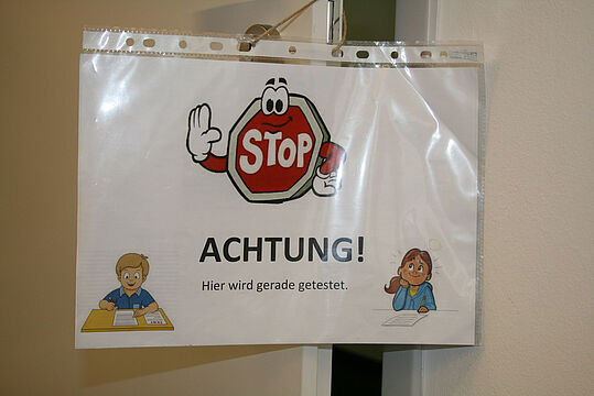 Schild mit Stopzeichen und Aufschrift "Achtung! Hier wird gerade getestet"